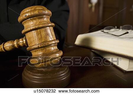 Stock Image - Judge using gavel in court, close-up. Fotosearch