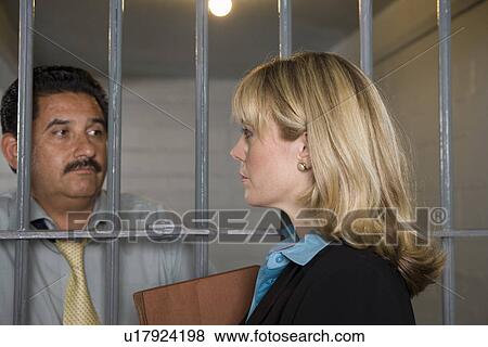 Lawyer with criminal behind bars in jail View Large Photo Image Stock Photo - Lawyer with criminal behind bars in jail. Fotosearch
