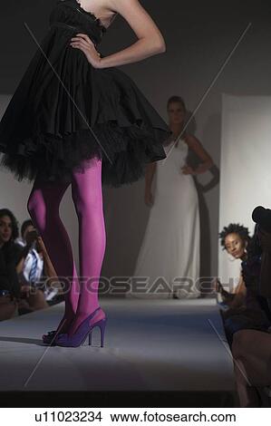 Picture - Low section of woman in pink tights and party dress on fashion catwalk. Fotosearch