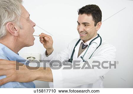 Stock Image - Male doctor examines senior patient. Fotosearch