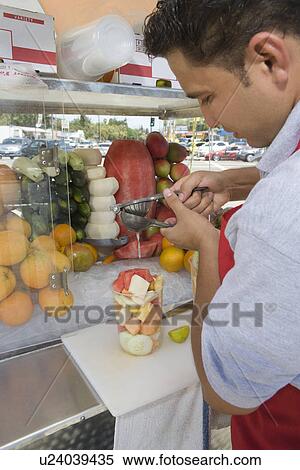 Stock Photography - Male street vendor preparing fruit salad. Fotosearch