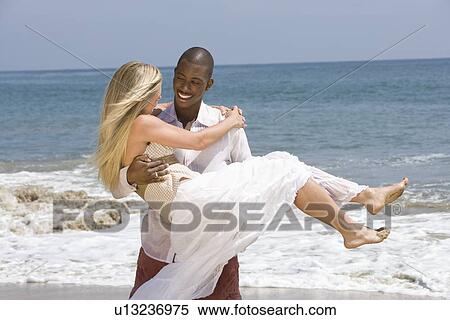 Man carrying woman on beach View Large Photo Image Stock Photography - Man carrying woman on beach. Fotosearch