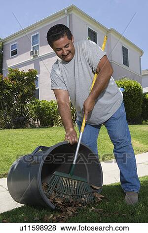 Stock Photo - Man raking leaves in garden. Fotosearch
