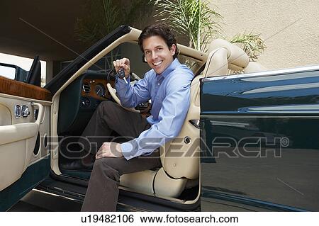 Man Sitting in a Convertible Holding Car Keys View Large Photo Image Stock Photograph - Man Sitting in a Convertible Holding Car Keys. Fotosearch