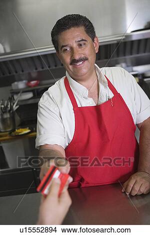 Man taking payment in restaurant View Large Photo Image Picture - Man taking payment in restaurant. Fotosearch