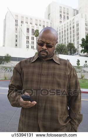 Man text messaging using mobile phone in street View Large Photo Image Stock Image - Man text messaging using mobile phone in street. Fotosearch