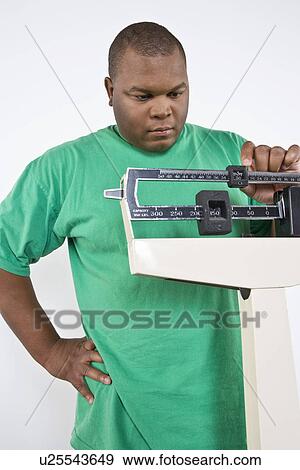 Man using weight scales View Large Photo Image Stock Photo - Man using weight scales. Fotosearch