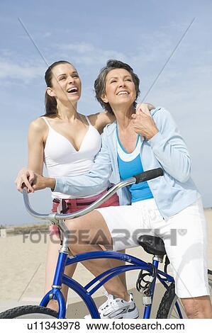 Stock Photo - Mature and Mid adult woman with bicycle. Fotosearch