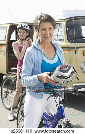 mature and mid adult women prepare for a cycle ride View Large Photo Image Stock Photo - mature and mid adult women prepare for a cycle ride. Fotosearch
