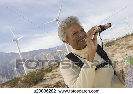 Mature woman with binoculars by wind farm View Large Photo Image Stock Image - Mature woman with binoculars by wind farm. Fotosearch