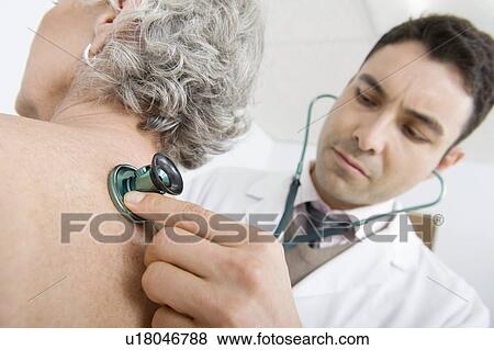 Stock Photo - Mid adult doctor checks breathing of senior patient. Fotosearch