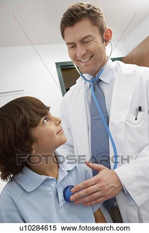 Stock Photography - Mid-adult doctor examining boy. Fotosearch