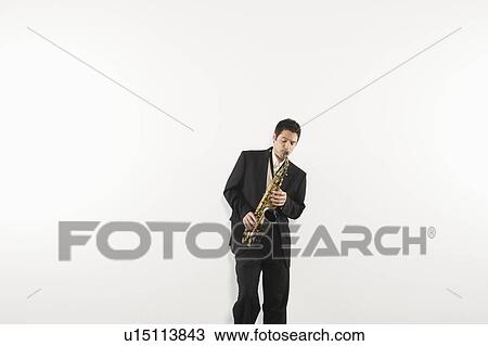 Mid adult man stands in suit playing the saxophone View Large Photo Image Stock Image - Mid adult man stands in suit playing the saxophone. Fotosearch