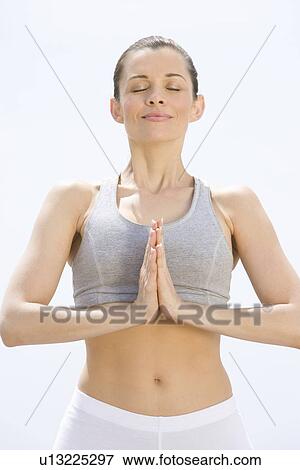 Mid adult woman stands in prayer position View Large Photo Image Stock Photo - Mid adult woman stands in prayer position. Fotosearch