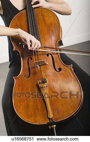 Mid section of woman bowing a cello View Large Photo Image Stock Image - Mid section of woman bowing a cello. Fotosearch