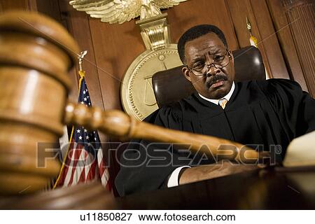 Stock Photo - Middle-aged judge, gavel in front of him. Fotosearch