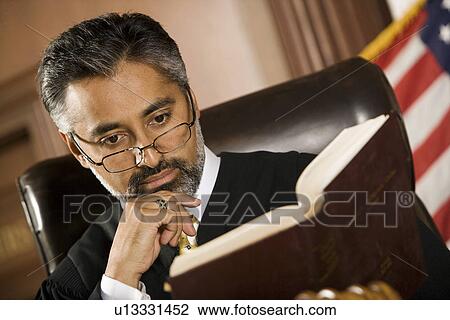 Middle-aged judge reading in a courtroom View Large Photo Image Stock Image - Middle-aged judge reading in a courtroom. Fotosearch