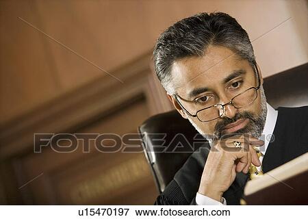 Middle-aged judge reading in a courtroom View Large Photo Image Stock Photo - Middle-aged judge reading in a courtroom. Fotosearch