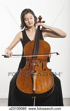 Stock Photo - Mixed race cellist sits playing. Fotosearch