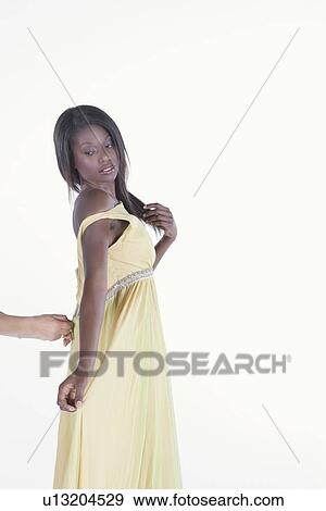 Model in yellow dress is helped with zip View Large Photo Image Stock Photo - Model in yellow dress is helped with zip. Fotosearch