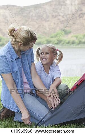 Stock Photograph - Mother and daughter pitch a tent. Fotosearch