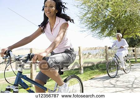 Mother and daughter race mountain bikes View Large Photo Image Stock Photo - Mother and daughter race mountain bikes. Fotosearch