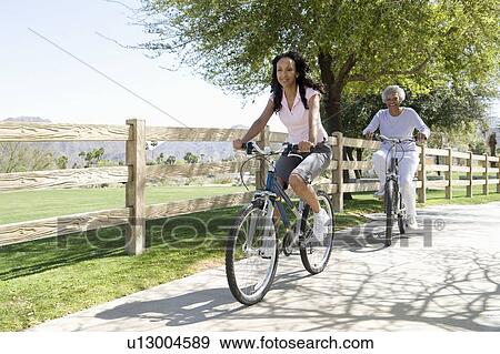 Mother and daughter race mountain bikes View Large Photo Image Stock Photo - Mother and daughter race mountain bikes. Fotosearch