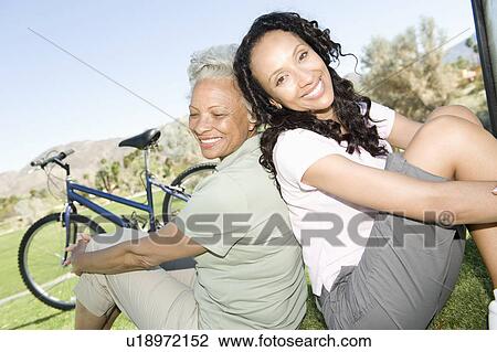Mother and daughter sit in park with mountain bikes View Large Photo Image Stock Image - Mother and daughter sit in park with mountain bikes. Fotosearch