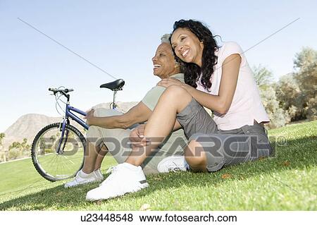 Mother and daughter sit in park with mountain bikes View Large Photo Image Stock Photo - Mother and daughter sit in park with mountain bikes. Fotosearch