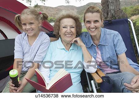 Mother, daughter and grand-daughter sit reading outside tent View Large Photo Image Stock Photo - Mother, daughter and grand-daughter sit reading outside tent. Fotosearch