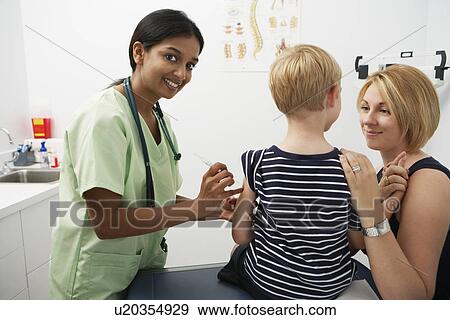 Stock Photo - Mother supporting boy receiving injection. Fotosearch