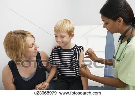 Stock Photo - Mother supporting son receiving injection. Fotosearch