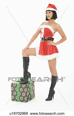 Stock Photo - Mrs Claus standing with one foot on gift. Fotosearch