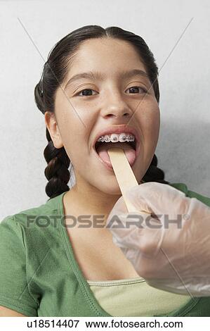 Nurse checking girls tongue in hospital View Large Photo Image Stock Photo - Nurse checking girls tongue in hospital. Fotosearch