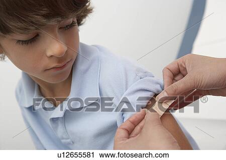 Nurse placing bandage on boy's arm, close up View Large Photo Image Stock Image - Nurse placing bandage on boy's arm, close up. Fotosearch