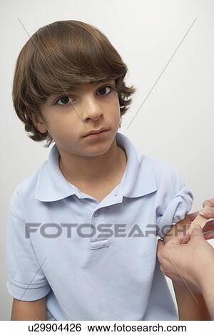 Nurse placing bandage on boy's arm View Large Photo Image Stock Photograph - Nurse placing bandage on boy's arm. Fotosearch