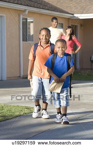 Parents watching children leave house View Large Photo Image Stock Photo - Parents watching children leave house. Fotosearch