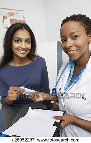 Stock Photo - Patient and female doctor smiling. Fotosearch