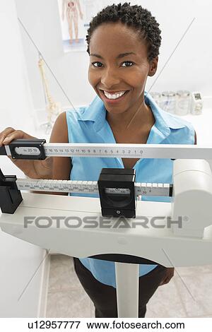 Portarit of smiling young woman with scales View Large Photo Image Stock Photo - Portarit of smiling young woman with scales. Fotosearch