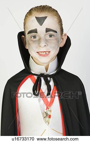 Stock Image - Portrait of boy (7-9) wearing dracula costume for Halloween. Fotosearch