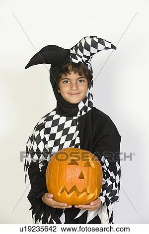 Portrait of boy (7-9) wearing jester costume, with jack-o-lantern View Large Photo Image Stock Image - Portrait of boy (7-9) wearing jester costume, with jack-o-lantern. Fotosearch