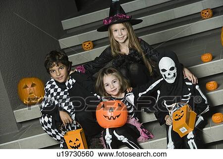Portrait of boys and girls (7-9) wearing Halloween costumes on steps View Large Photo Image Stock Image - Portrait of boys and girls (7-9) wearing Halloween costumes on steps. Fotosearch
