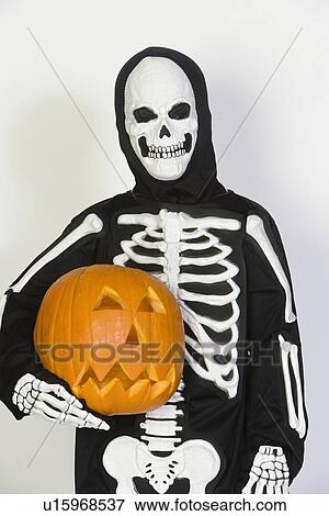Portrait of child (7-9) wearing skeleton costume, with jack-o-lantern View Large Photo Image Stock Photo - Portrait of child (7-9) wearing skeleton costume, with jack-o-lantern. Fotosearch