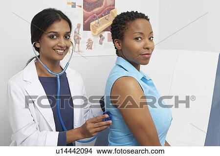 Portrait of female doctor examining patient View Large Photo Image Picture - Portrait of female doctor examining patient. Fotosearch