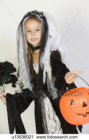 Portrait of girl (7-9) wearing Halloween costume with jack-o-lantern View Large Photo Image Stock Image - Portrait of girl (7-9) wearing Halloween costume with jack-o-lantern. Fotosearch