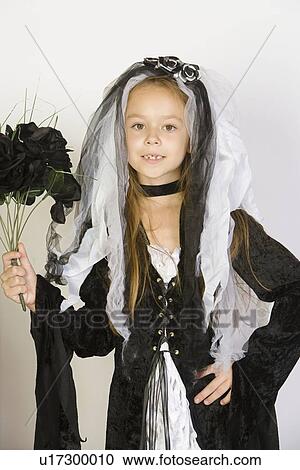 Stock Image - Portrait of girl (7-9) wearing Halloween costume. Fotosearch