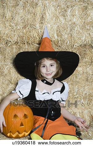 Portrait of girl (7-9) wearing witch costume by hay View Large Photo Image Stock Photo - Portrait of girl (7-9) wearing witch costume by hay. Fotosearch