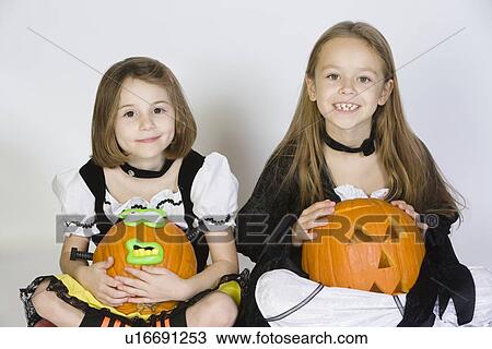Portrait of girls (7-9) wearing Halloween costumes, with jack-o-lanterns View Large Photo Image Stock Image - Portrait of girls (7-9) wearing Halloween costumes, with jack-o-lanterns. Fotosearch