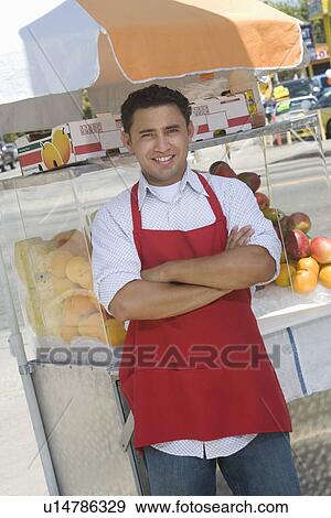 Stock Photo - Portrait of male street vendor by stall. Fotosearch