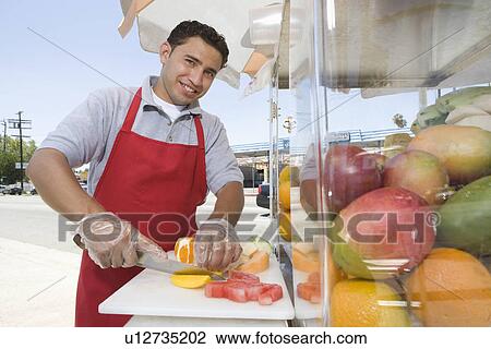 Portrait of male street vendor chopping fruit View Large Photo Image Stock Image - Portrait of male street vendor chopping fruit. Fotosearch